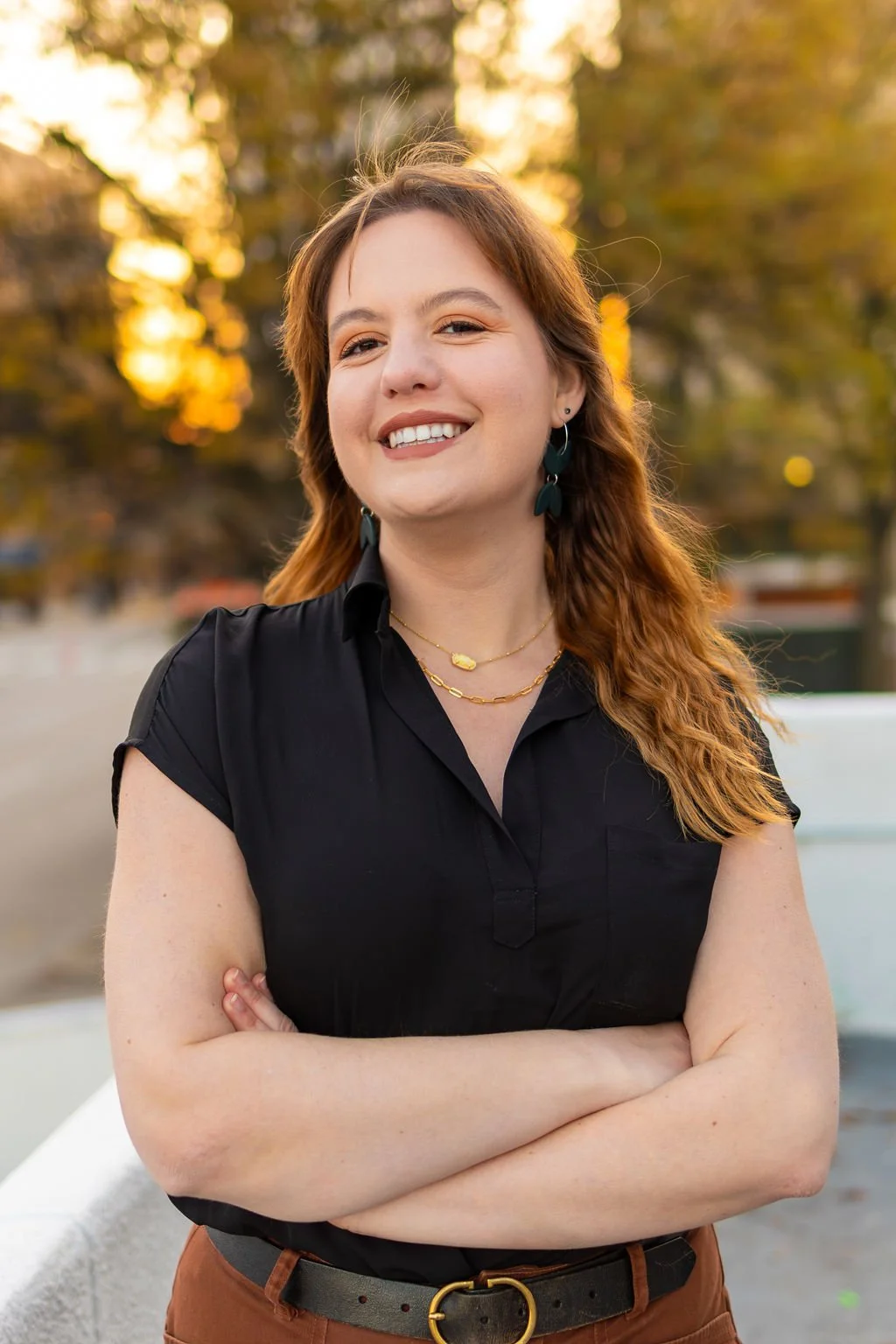 Photograph of Alex Isaak posing with arms crossed outside