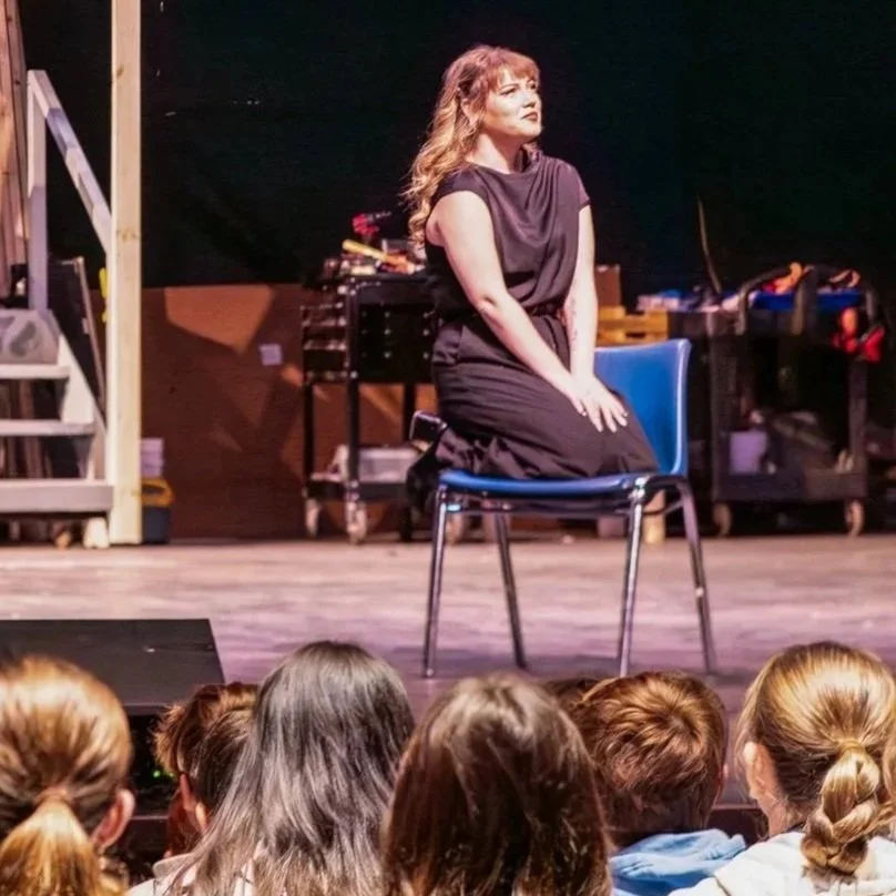 Photograph of students watching TSC Company member Ashe Baileigh perform