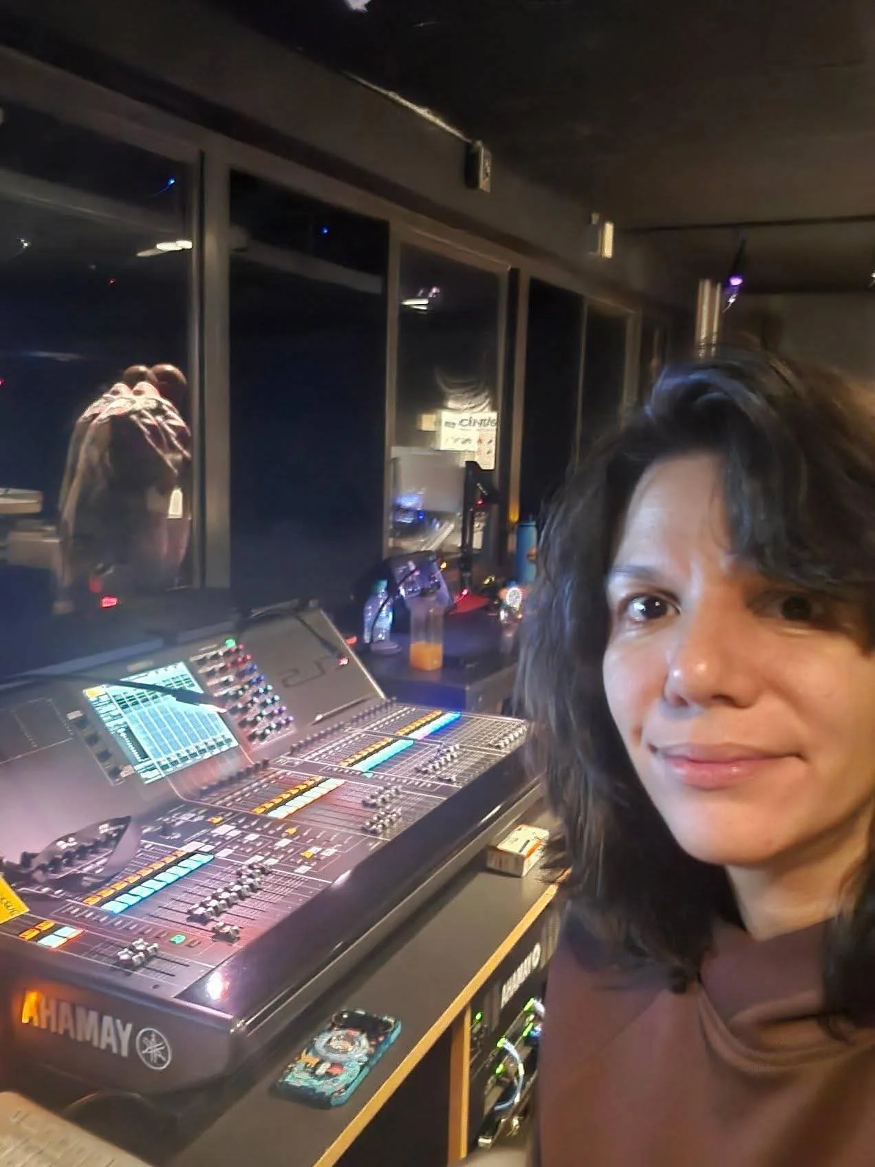 Photograph of Angel Ruiz sitting in front of a sound board