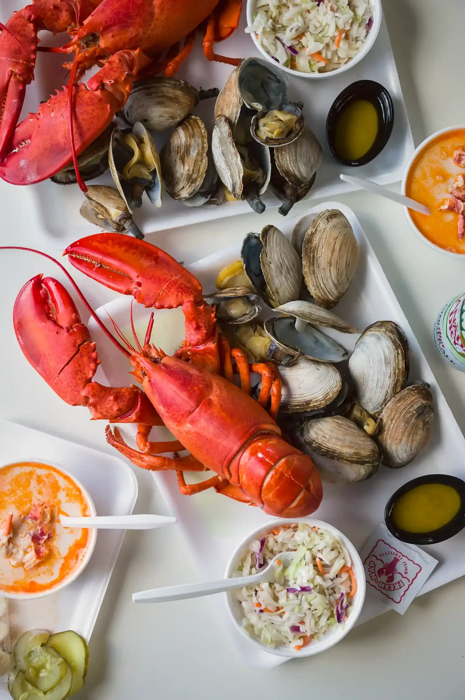 Lobster bake on a tray with butter & coleslaw. By Philadelphia, PA & NJ food photographer & food stylist team Bartholomew Studio.