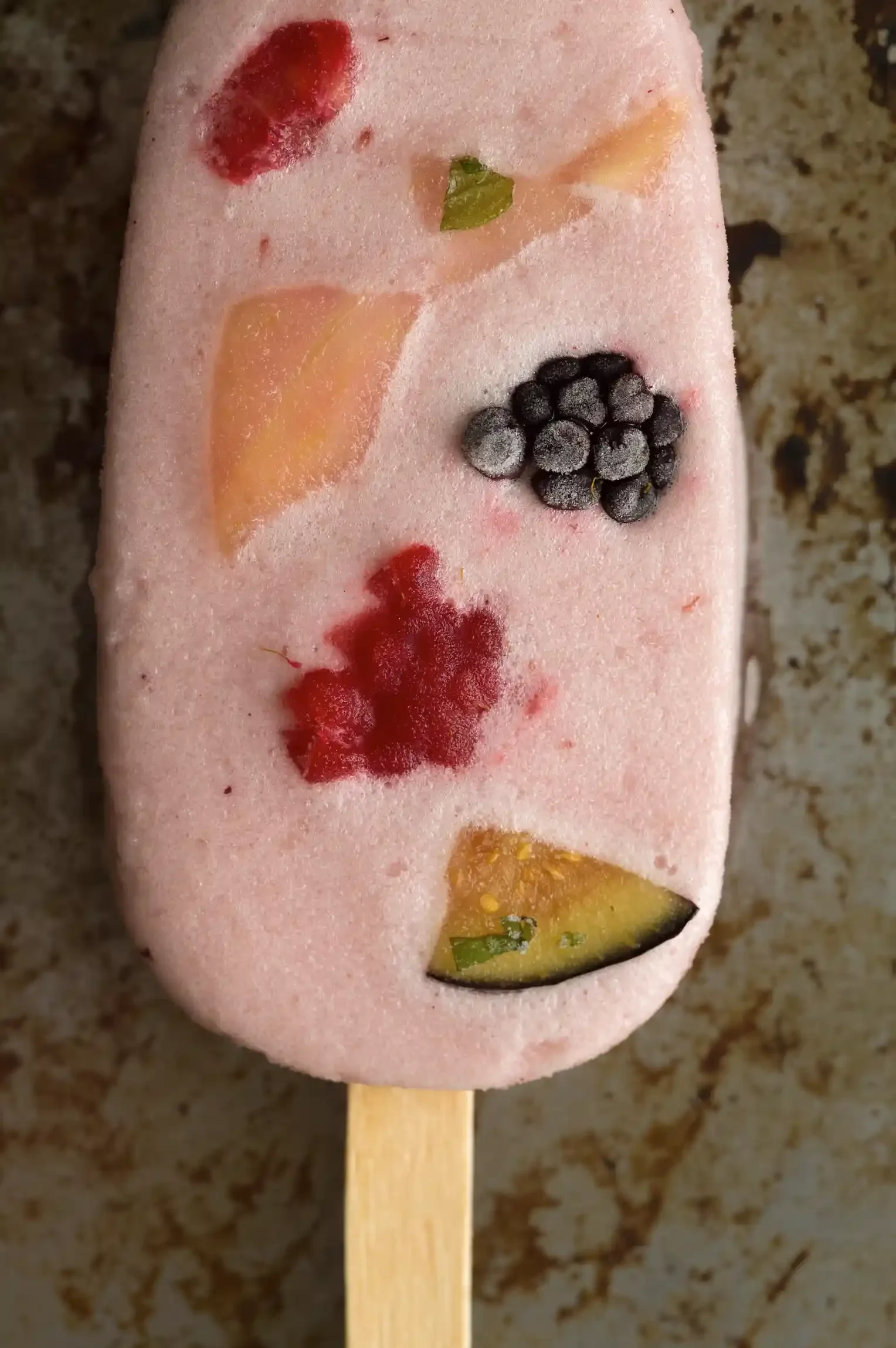 Popsicle with frozen fruit pieces. By Bucks County, PA & New Jersey food photographer & food stylist team Bartholomew Studio.
