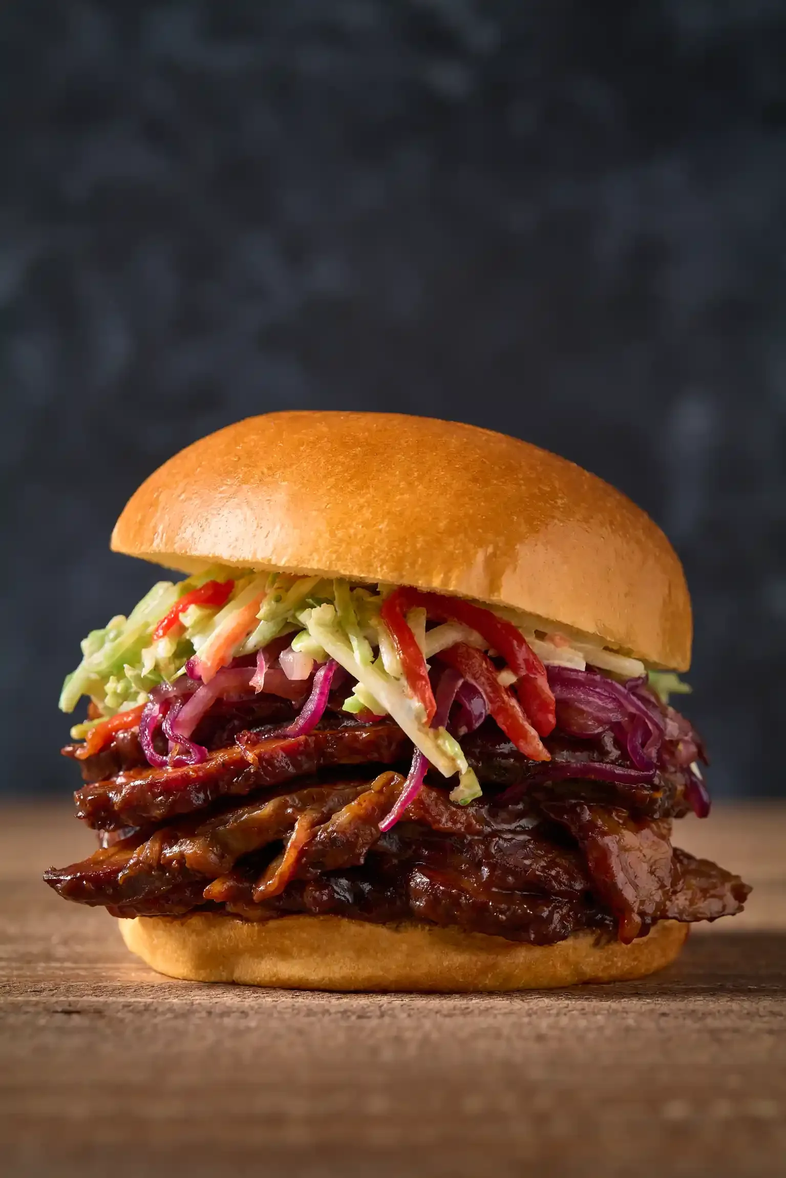 BBQ pulled pork sandwich with coleslaw on a bun. By Philadelphia, PA & NJ food photographer & food stylist team Bartholomew Studio.