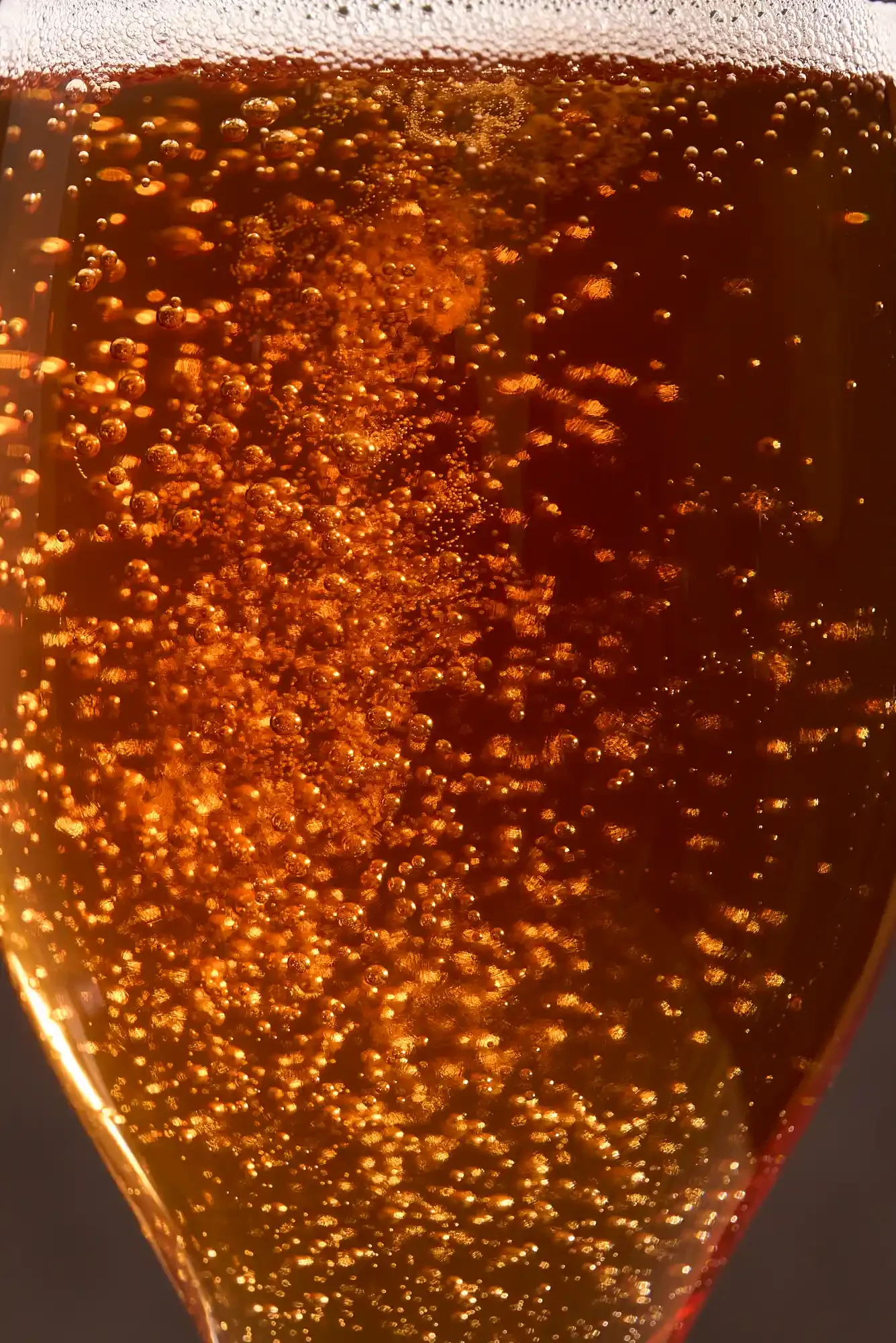 Close-up of a glass filled with champagne, showing bubbles rising to the top. By PA, NJ & NYC drink photographer & drink stylist team Bartholomew Studio.