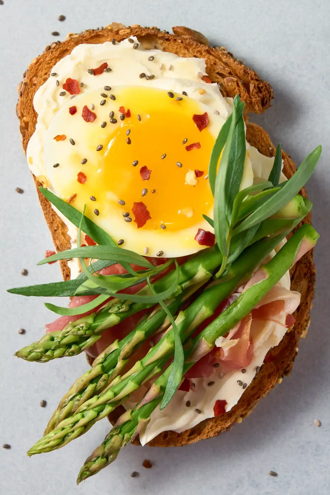 Open-faced toast with a fried egg, asparagus, herbs, and spices. By Philadelphia, PA food photographer & food stylist team Bartholomew Studio.
