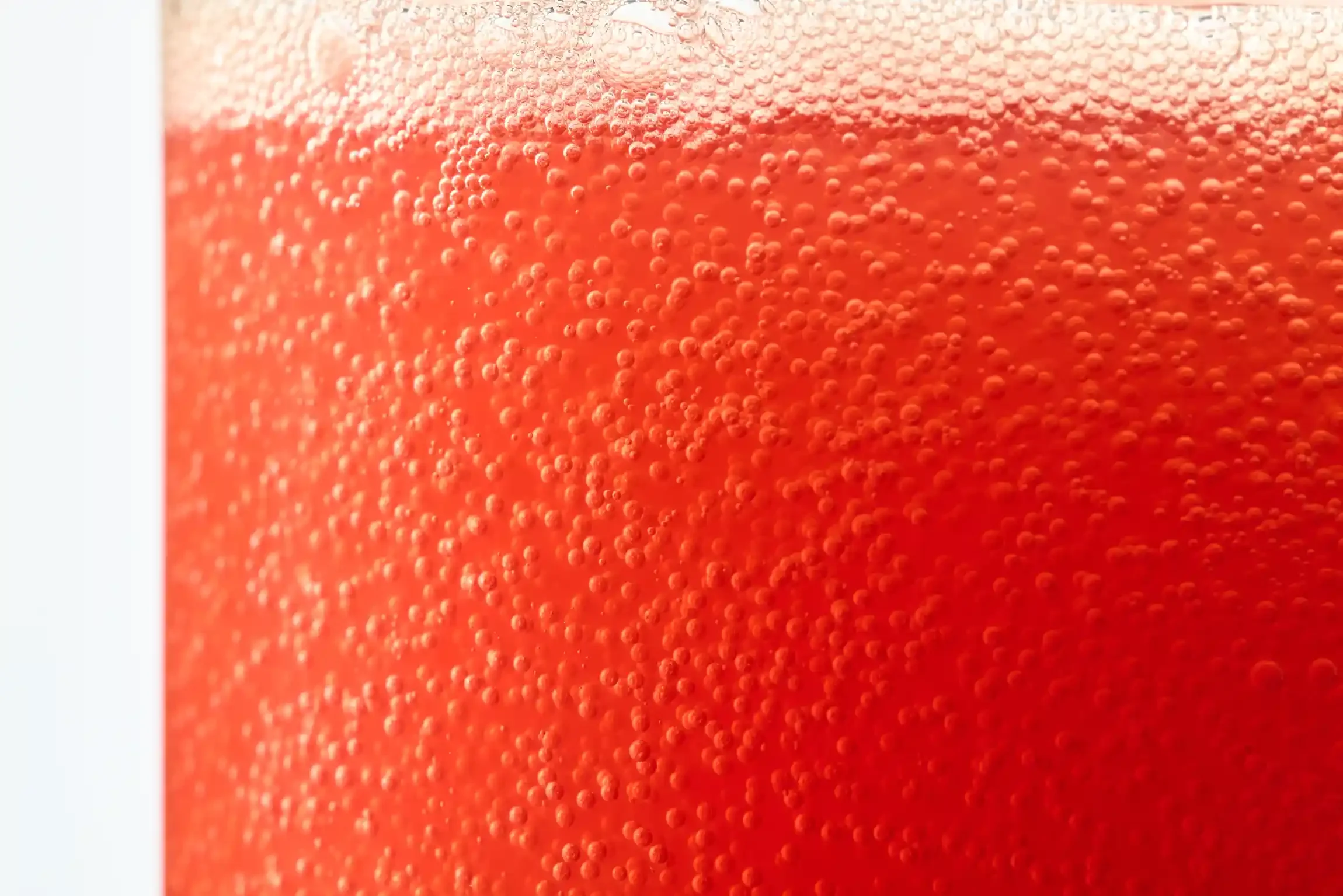 Close-up of a red beverage with bubbles. By Philadelphia, PA & NJ beverage photographer & drink stylist team Bartholomew Studio.