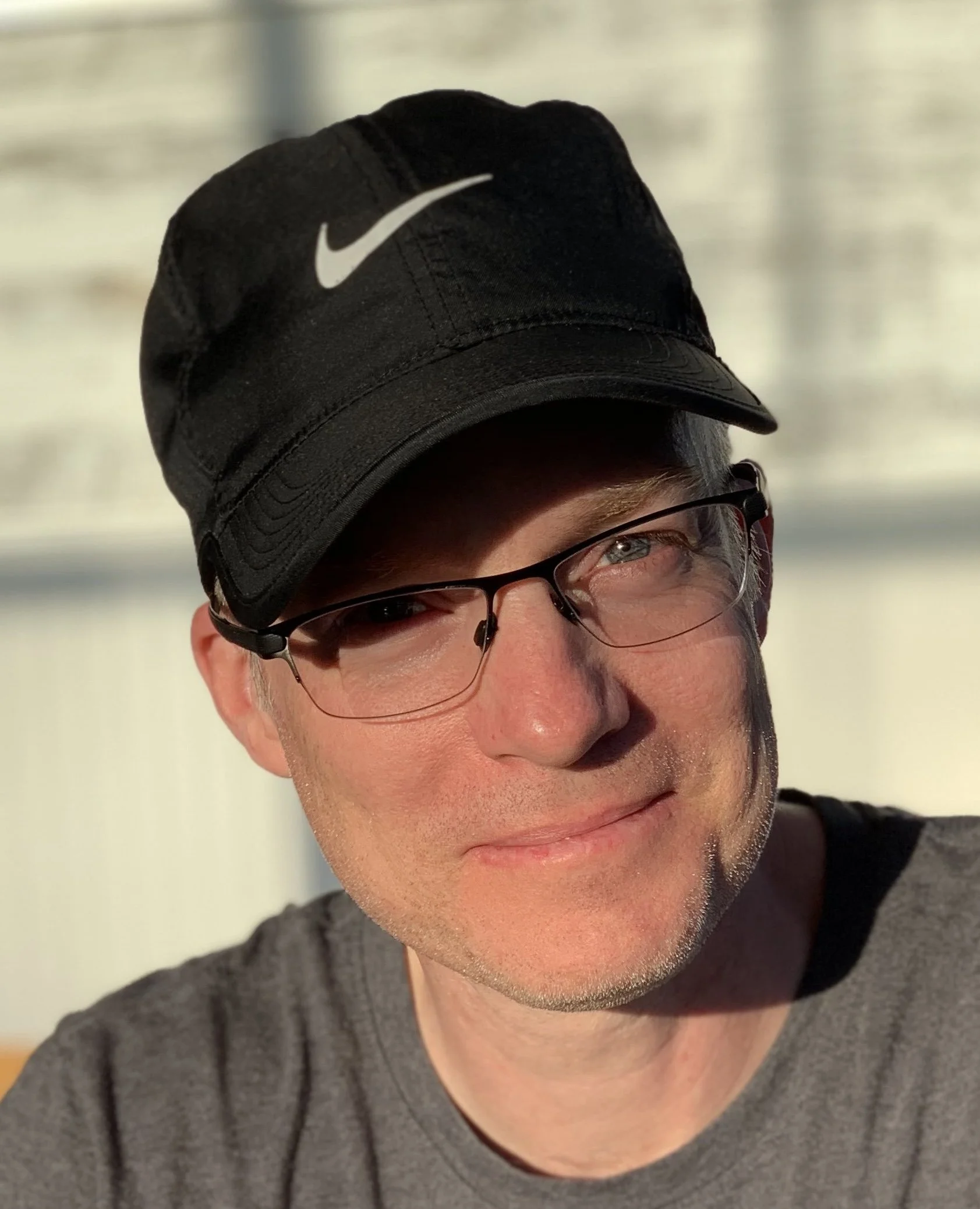 Photo of Toph wearing a black baseball cap and smiling at the camera.