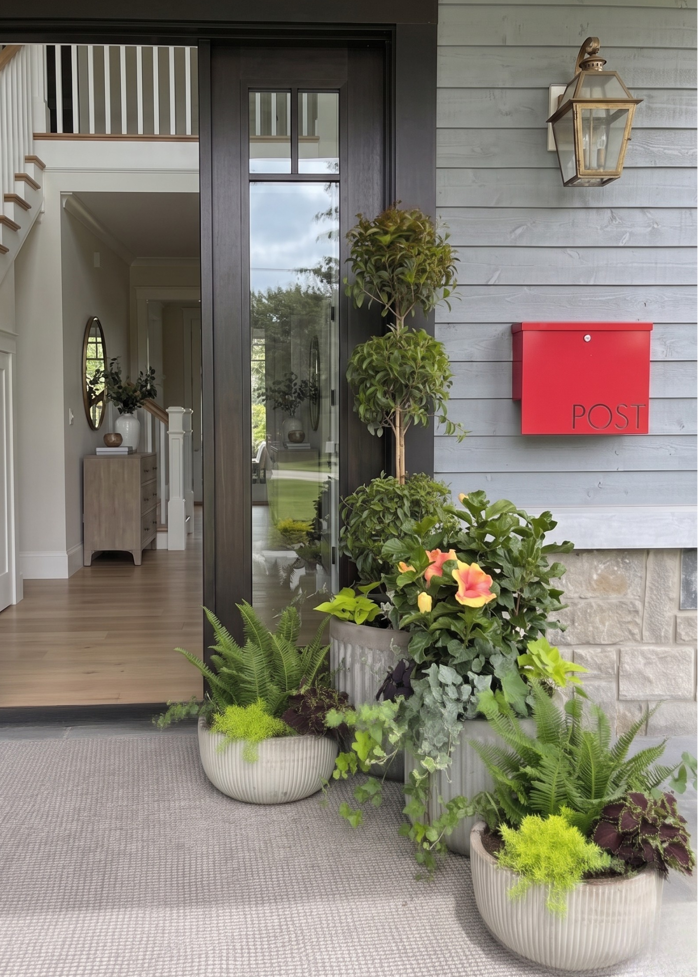 Entryway of a house with three large potted plants and a red mailbox labeled 'POST' on the exterior wall.