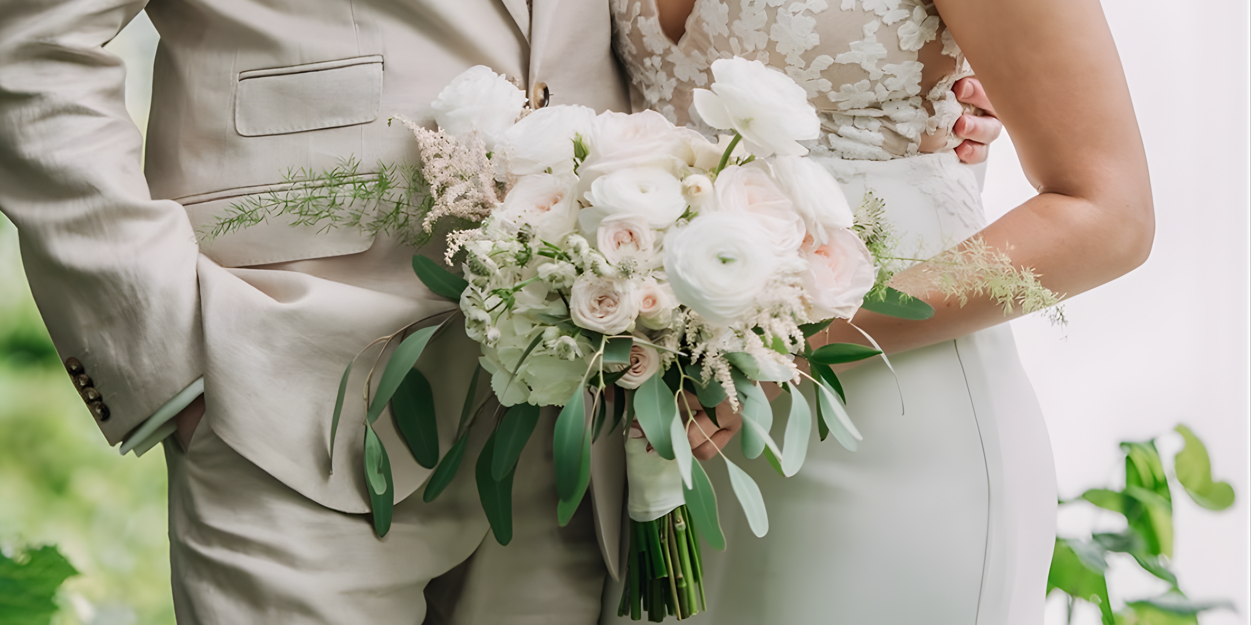 Close-up of a bride and groom holding a bouquet of white and pale pink flowers.