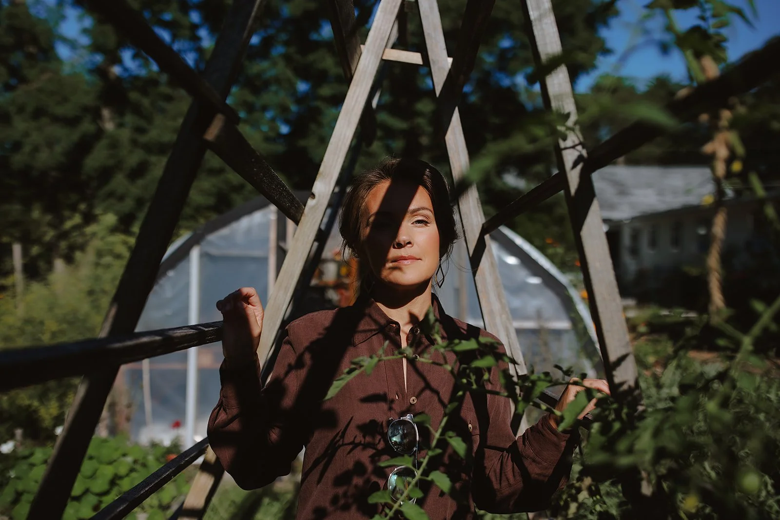 Editorial branding portrait of female entrepreneur standing in her victory garden