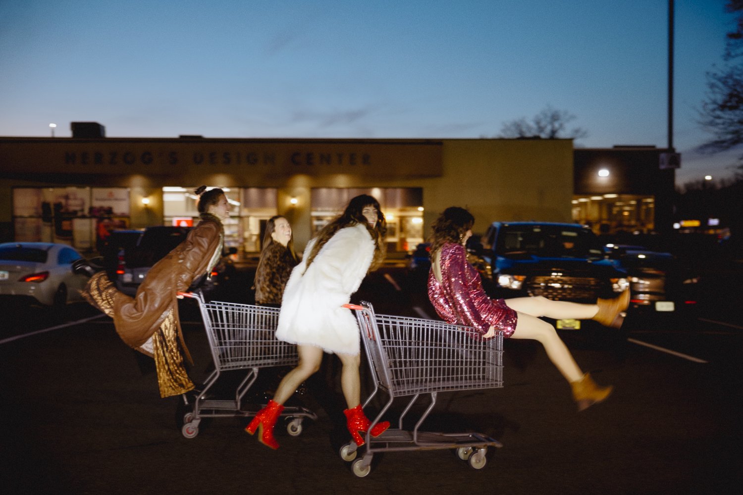 Editorial branding portrait of female founder and coach celebrating sisterhood in the parking lot at night