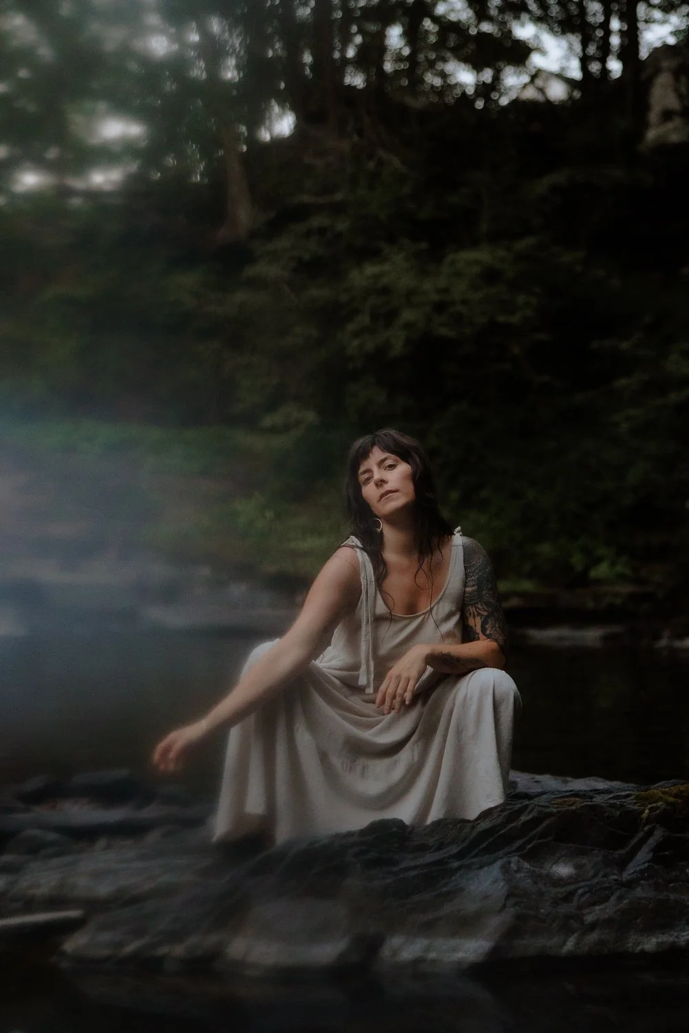 Editorial branding portrait of female artist washing herself in the river