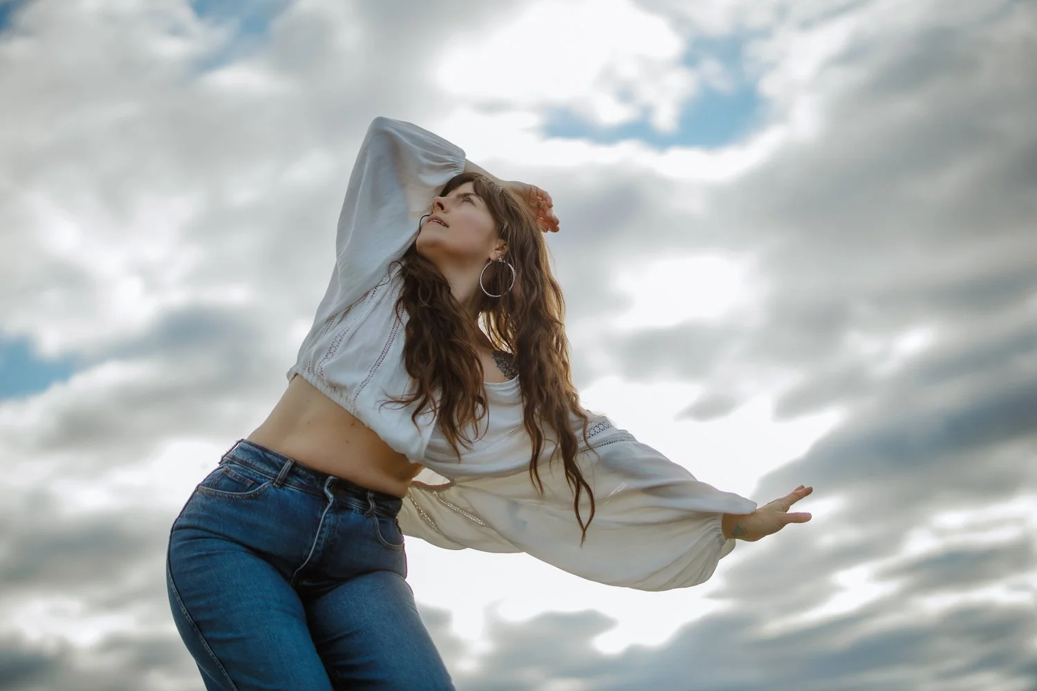 Editorial branding portrait of female women's coach not stretching her arms out against the blue sky