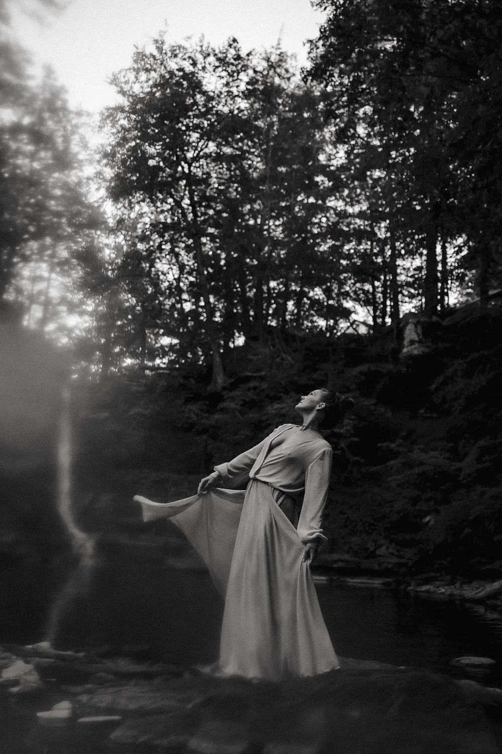 Editorial branding portrait of female entrepreneur dancing at a waterfall