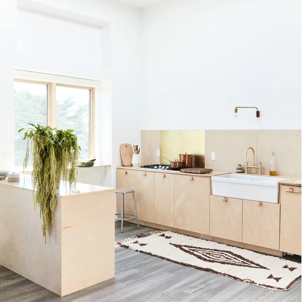 white-walls-and-wood-accents-create-a-subdued-relaxing-vibe-a-skylight-draws-light-into-the-cooking-and-living-spaces-from-above-while-large-windows-provide-views-of-the-california-scenery.jpg
