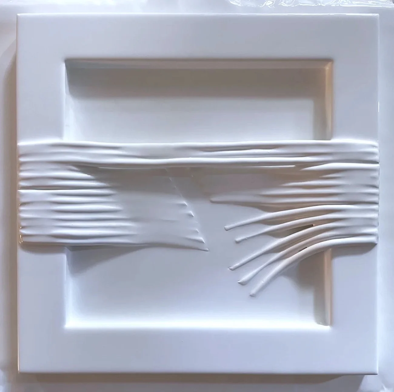 Cutting Cord, 2026. Clay and gesso pour on woodboard.