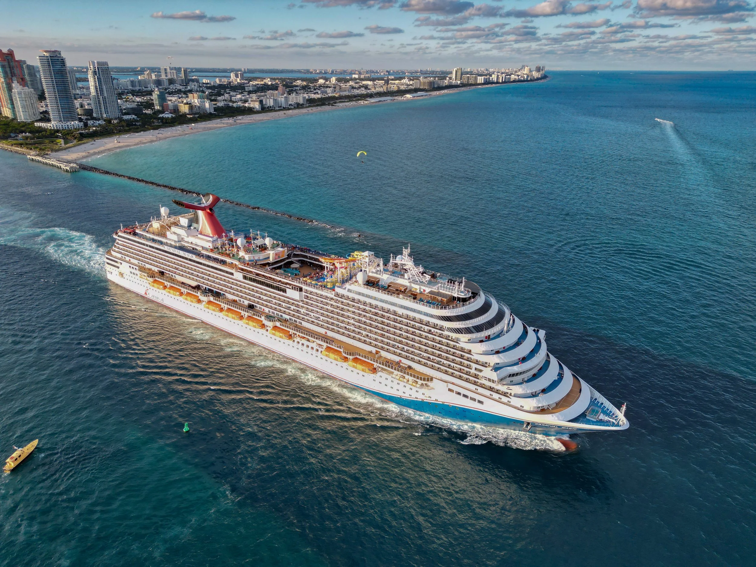 Large cruise ship leaving port on calm blue water under a clear sky