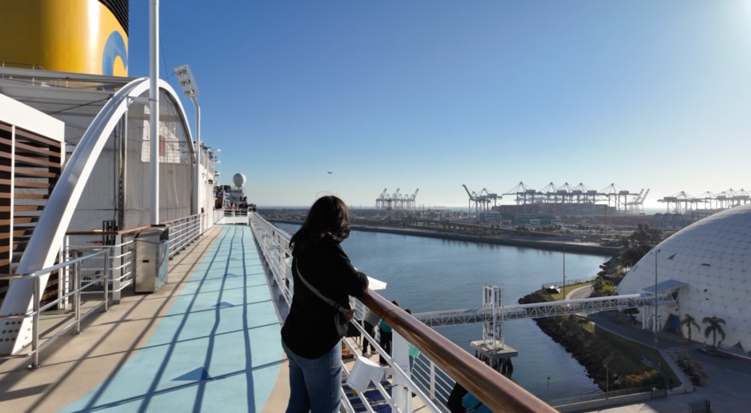 Traveler looking out from a cruise ship deck while deciding the right cruise length