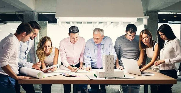 Group of professionals working on a project around a table in a modern office.