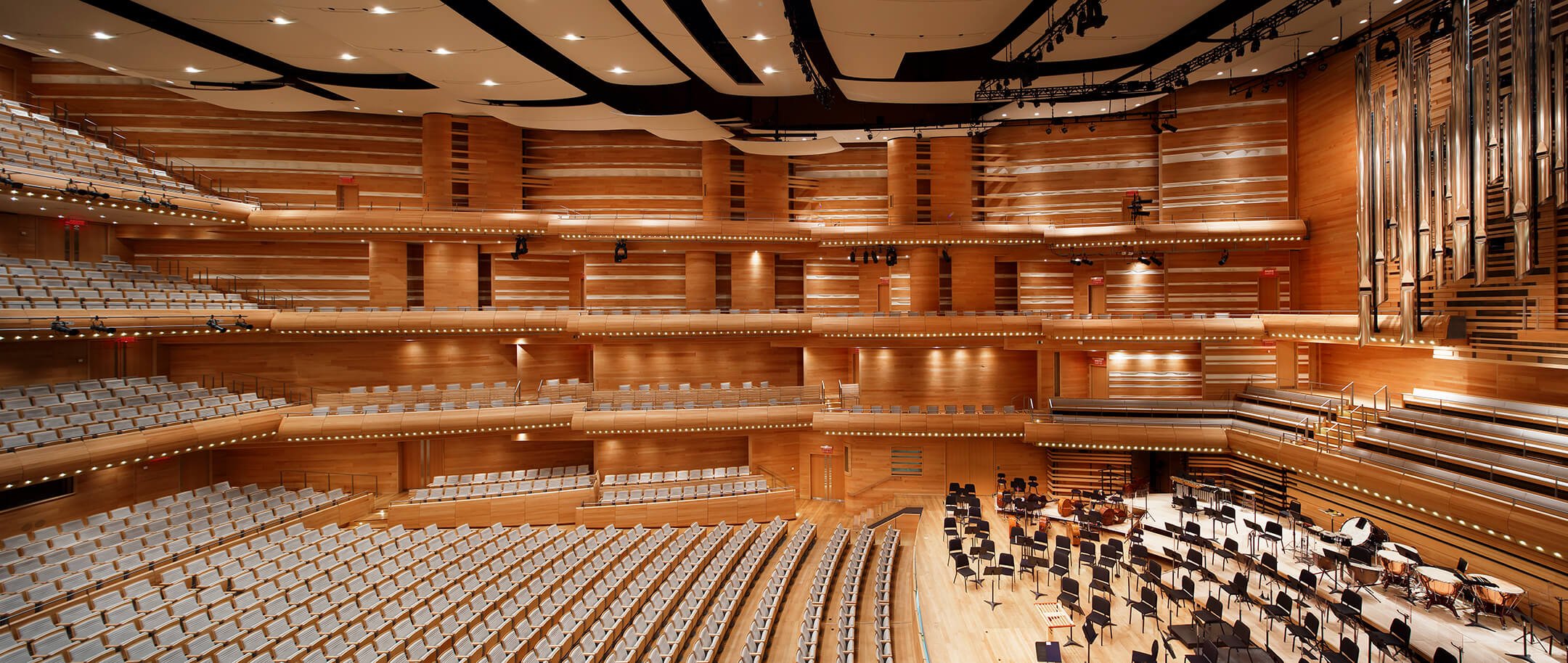 Grand auditorium vide avec un orchestre en préparation.