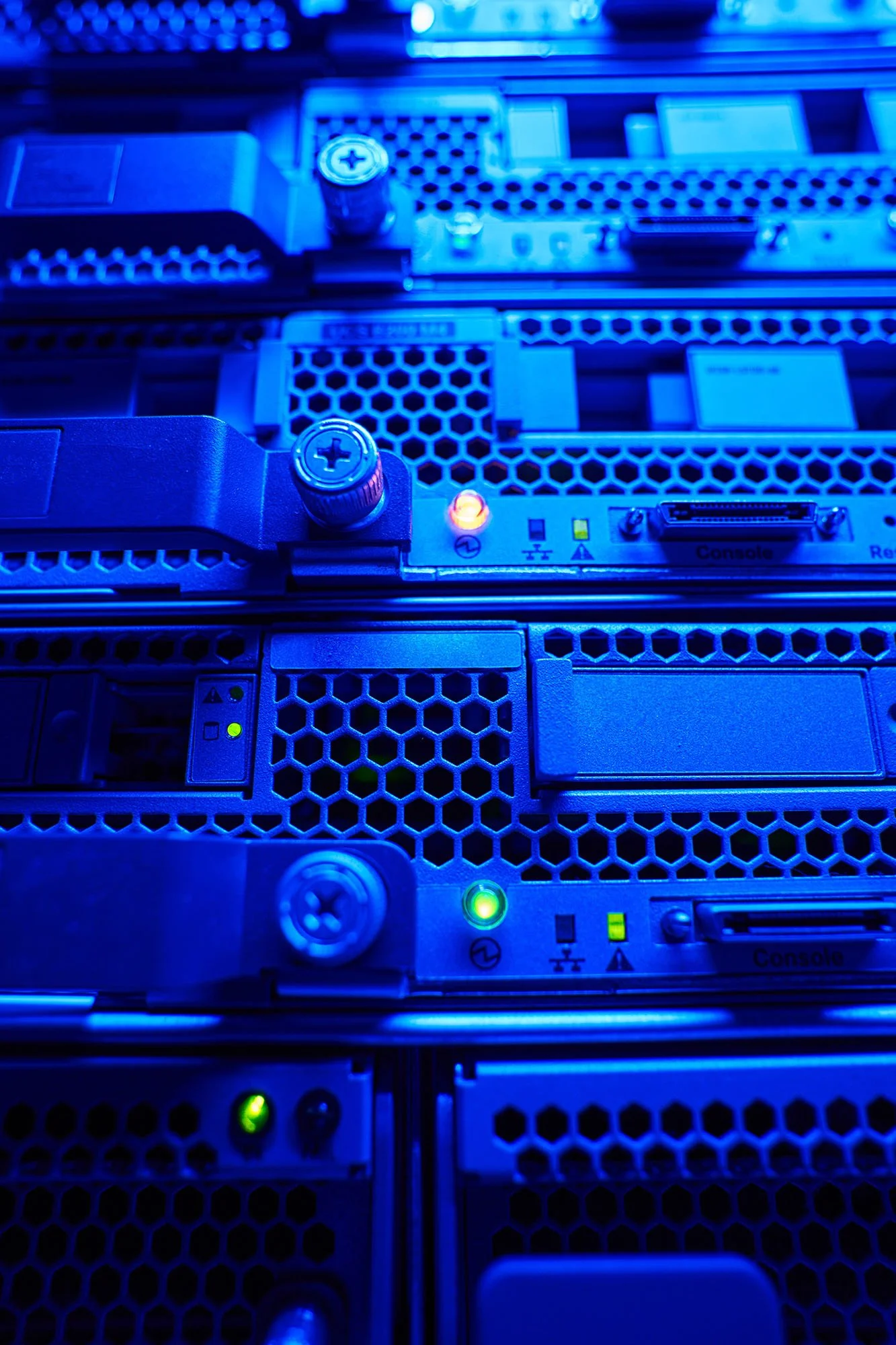 Close-up of server hardware components illuminated in blue lighting, showing circuit boards, connectors, and indicator lights.