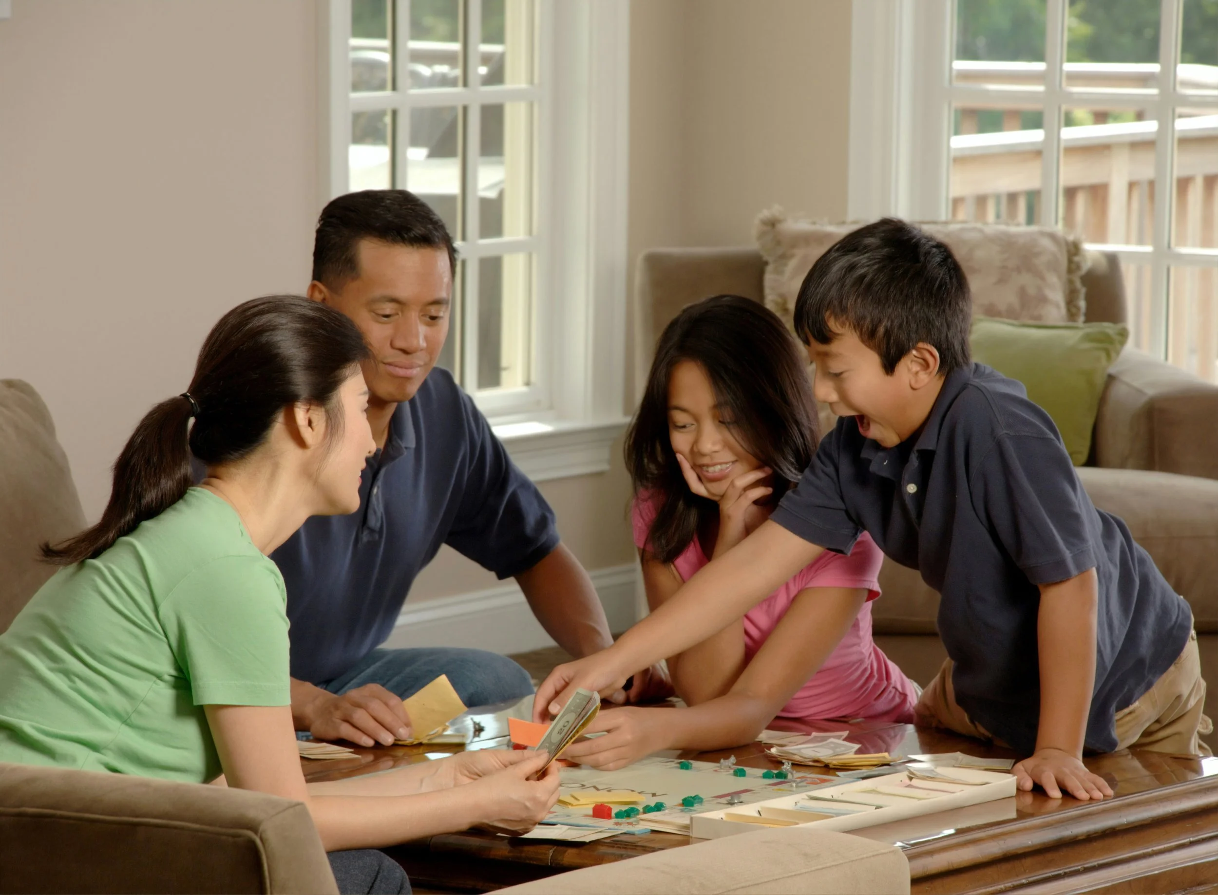 A family with children who have ADHD, autism, or PDA enjoying time playing games together.