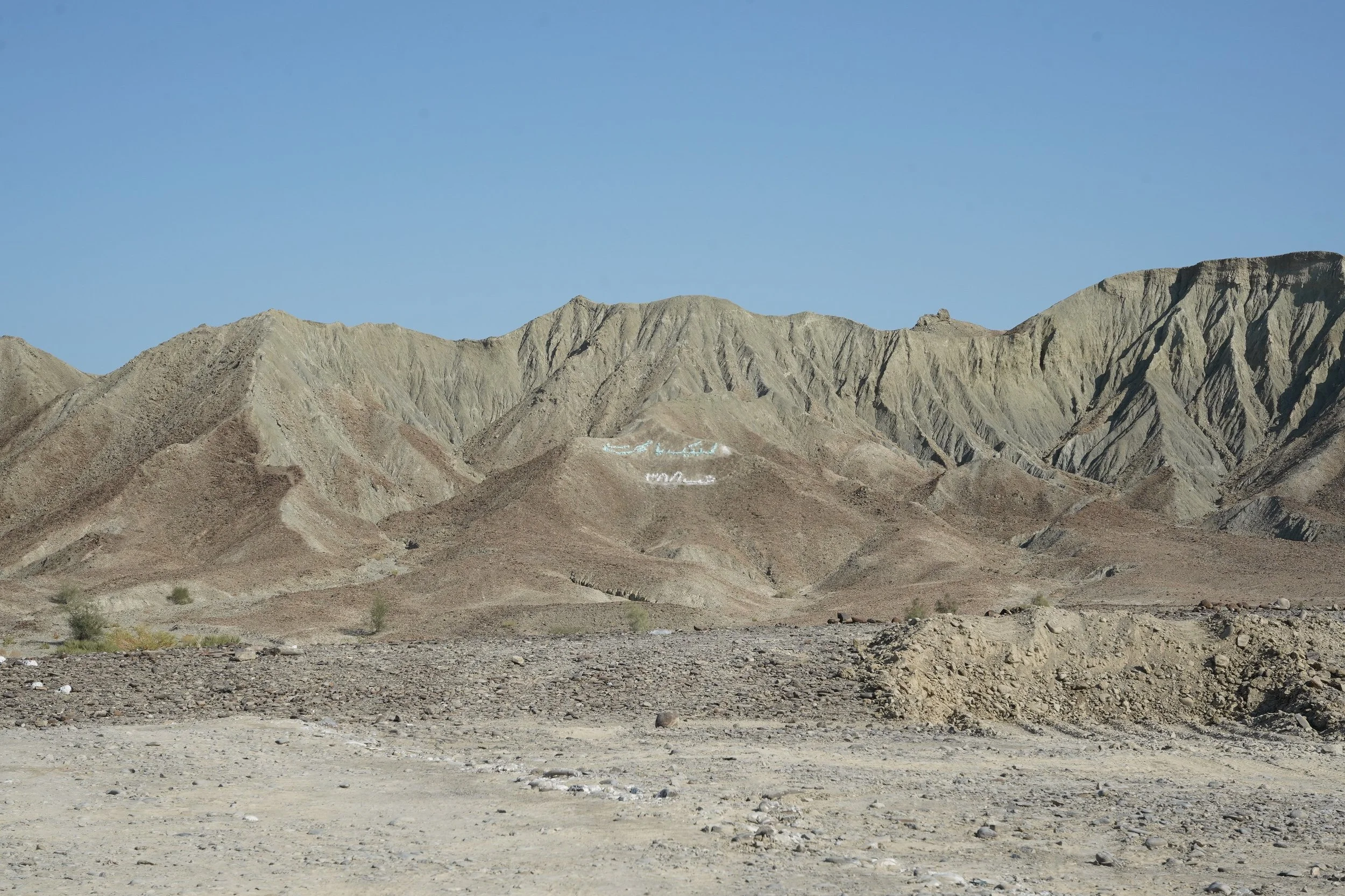 Desert landscape with rugged mountains and a clear blue sky.