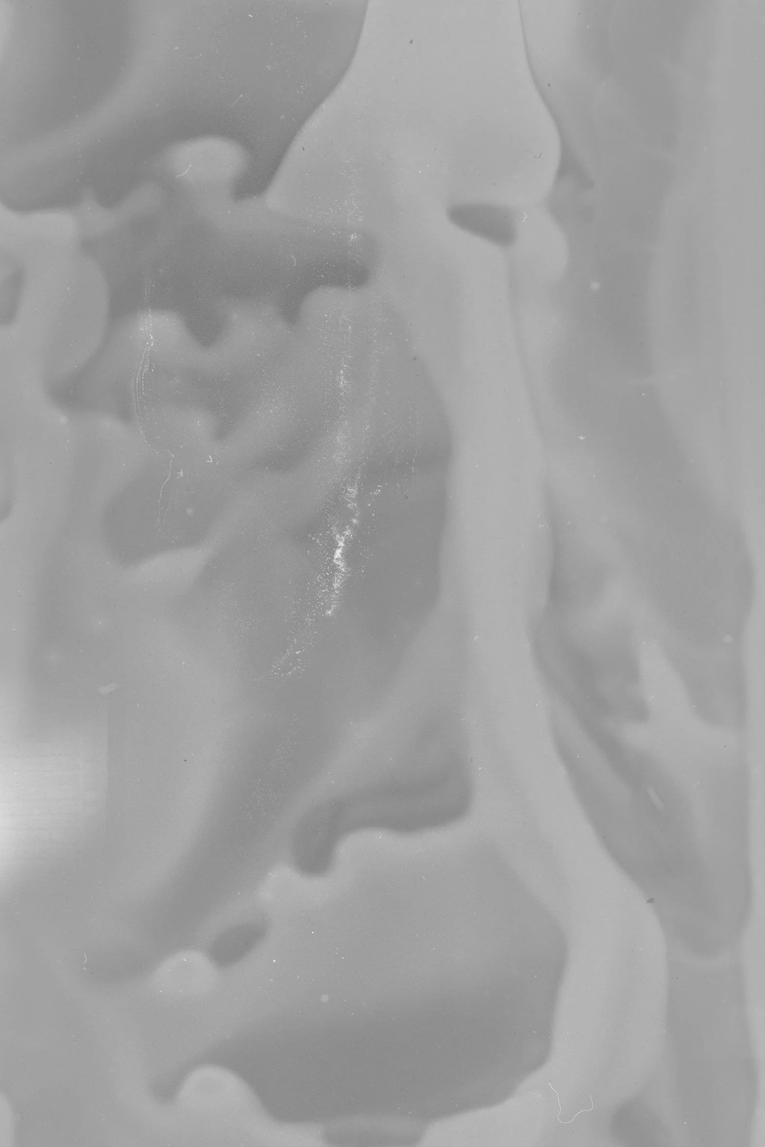 Close-up black and white photo of two faces in profile, face-to-face, with a wispy, smoky background.