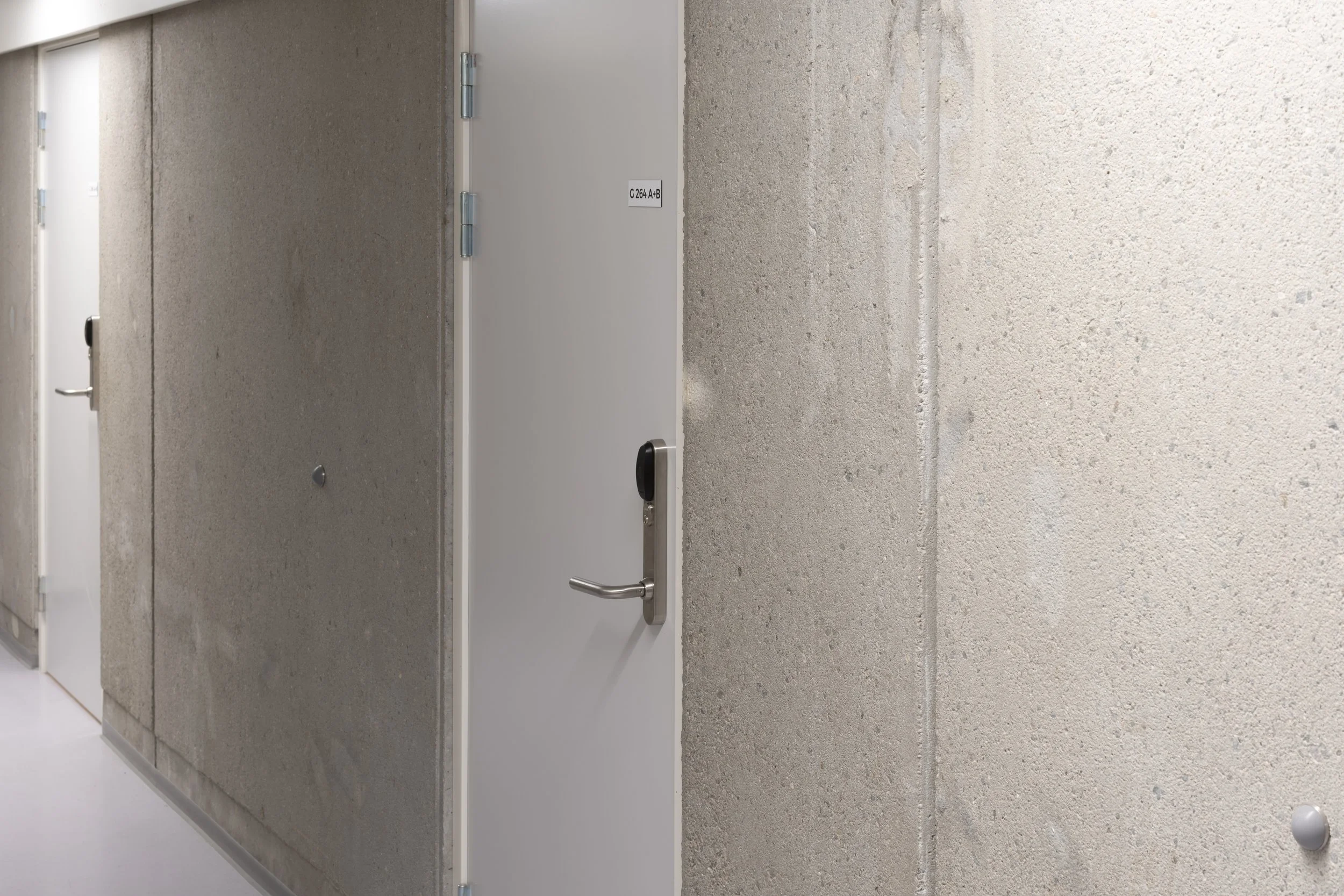 Interior hallway with several closed white doors and textured beige walls