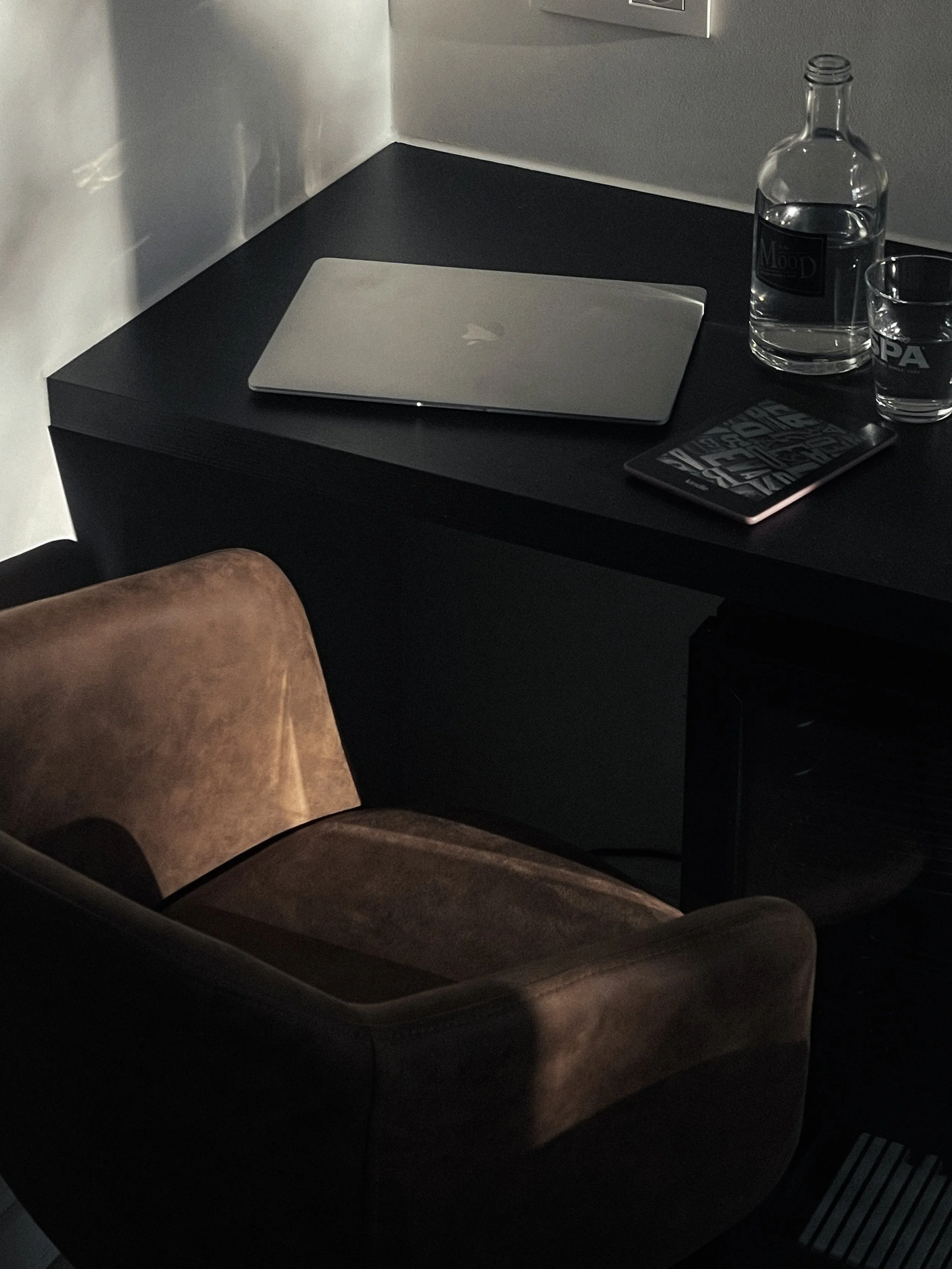 Minimal dark workspace with a laptop and glass of water — editorial brand detail image, Elevated Accounting