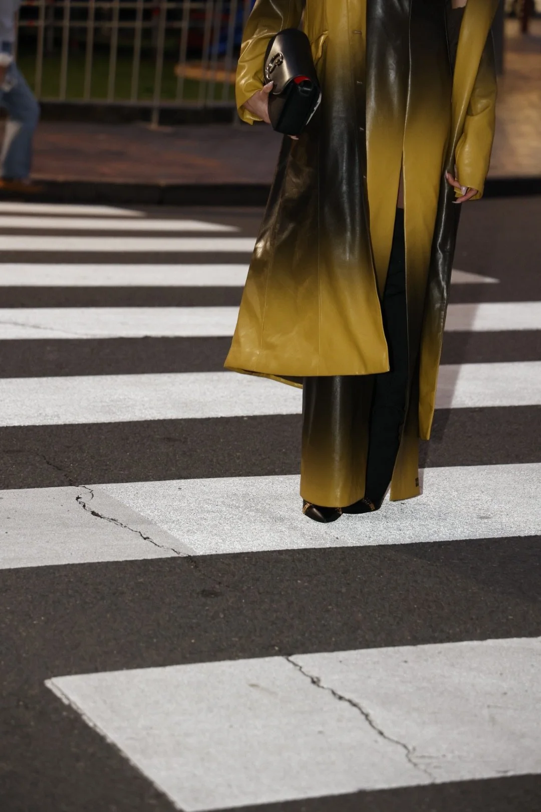 Woman in a mustard yellow coat crossing a street — editorial lifestyle image representing the elevated, intentional business owner, Elevated Accounting