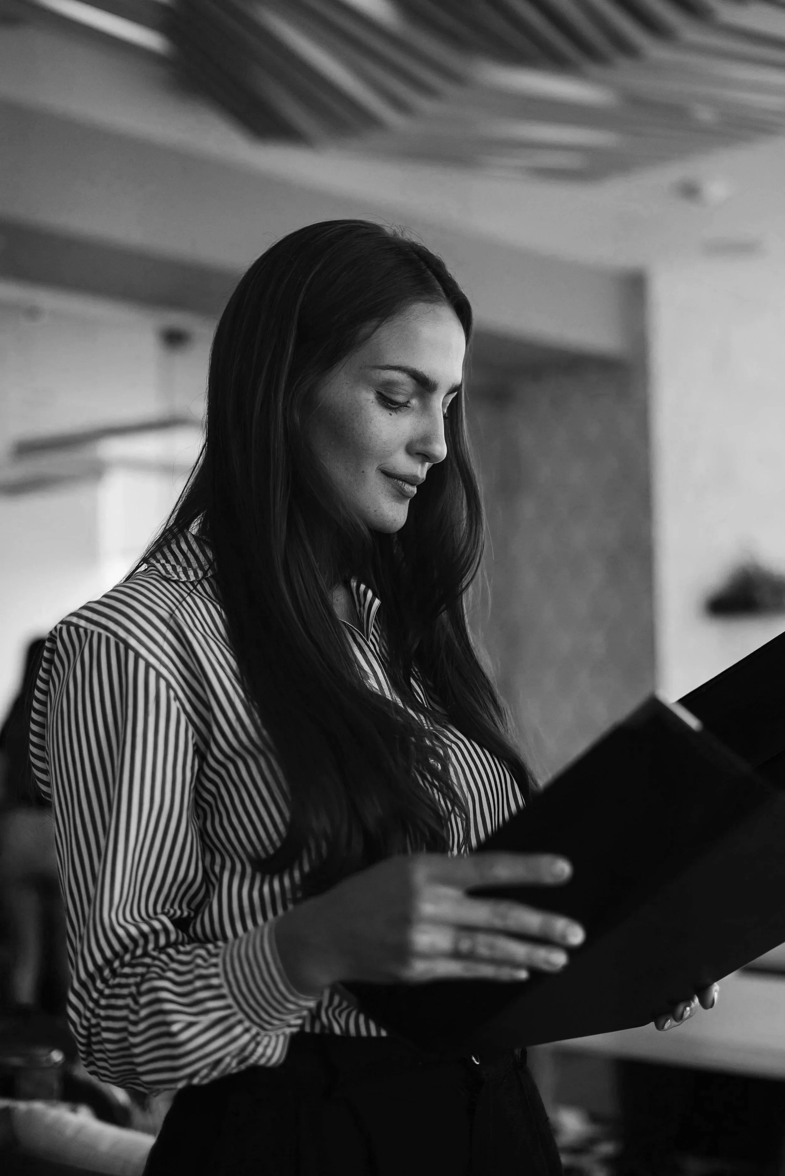 Close-up of hands holding a clipboard or notepad in a professional setting — black and white editorial photo, Elevated Accounting