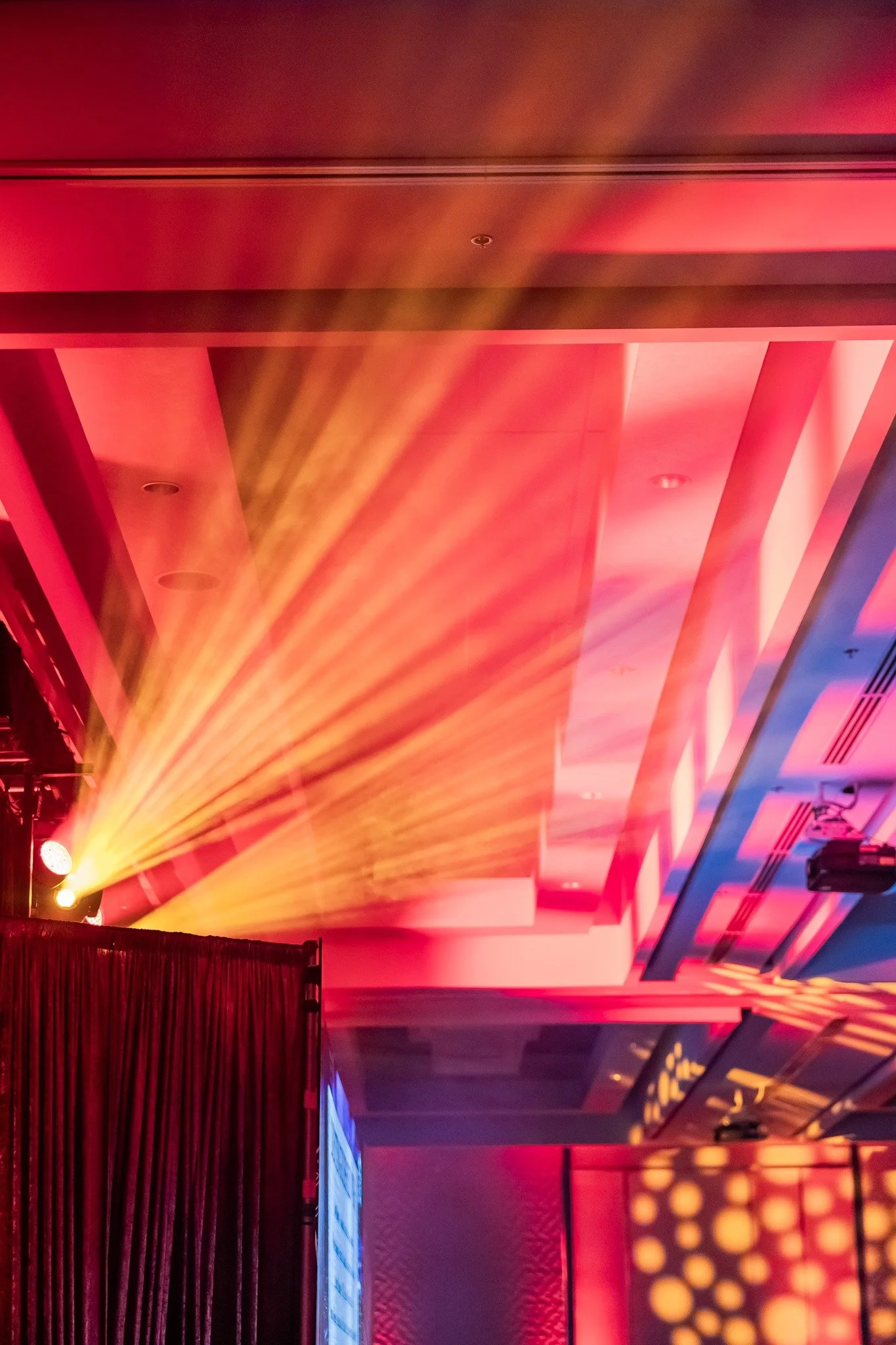 Colorful stage lighting and ceiling design in a venue or conference hall.