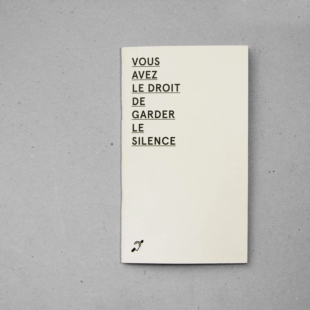 Une affiche blanche avec le texte noir : "VOUS AVEZ LE DROIT DE GARDER LE SILENCE" en majuscules, avec une petite icône en bas à gauche représentant une oreille avec une ligne traversant.