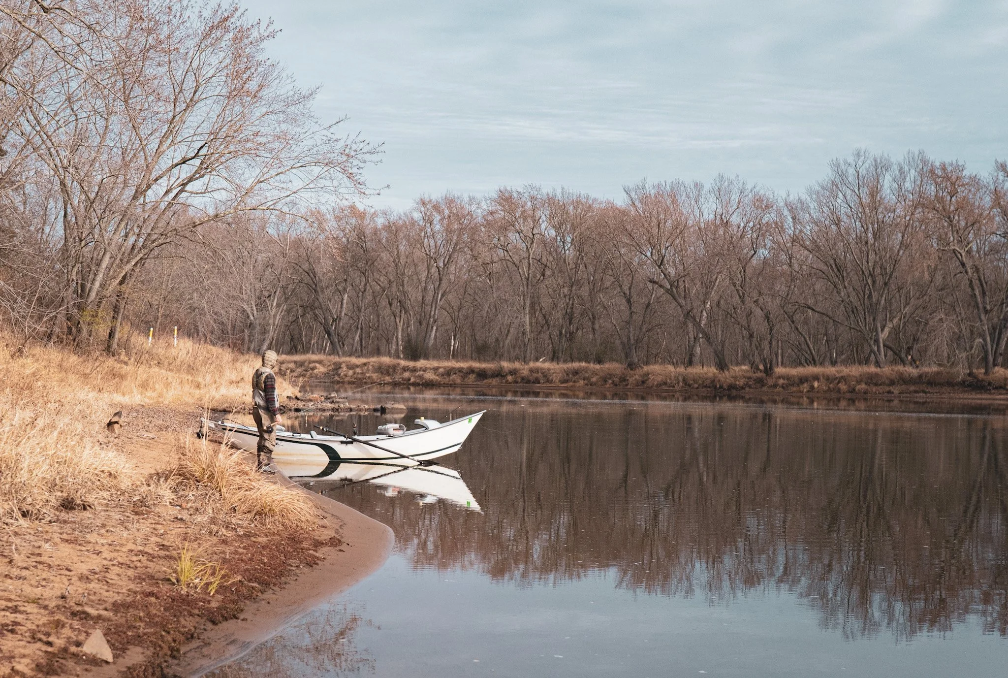 Fly Fishing guide standing next to his drift boat on the beautiful Mississippi River