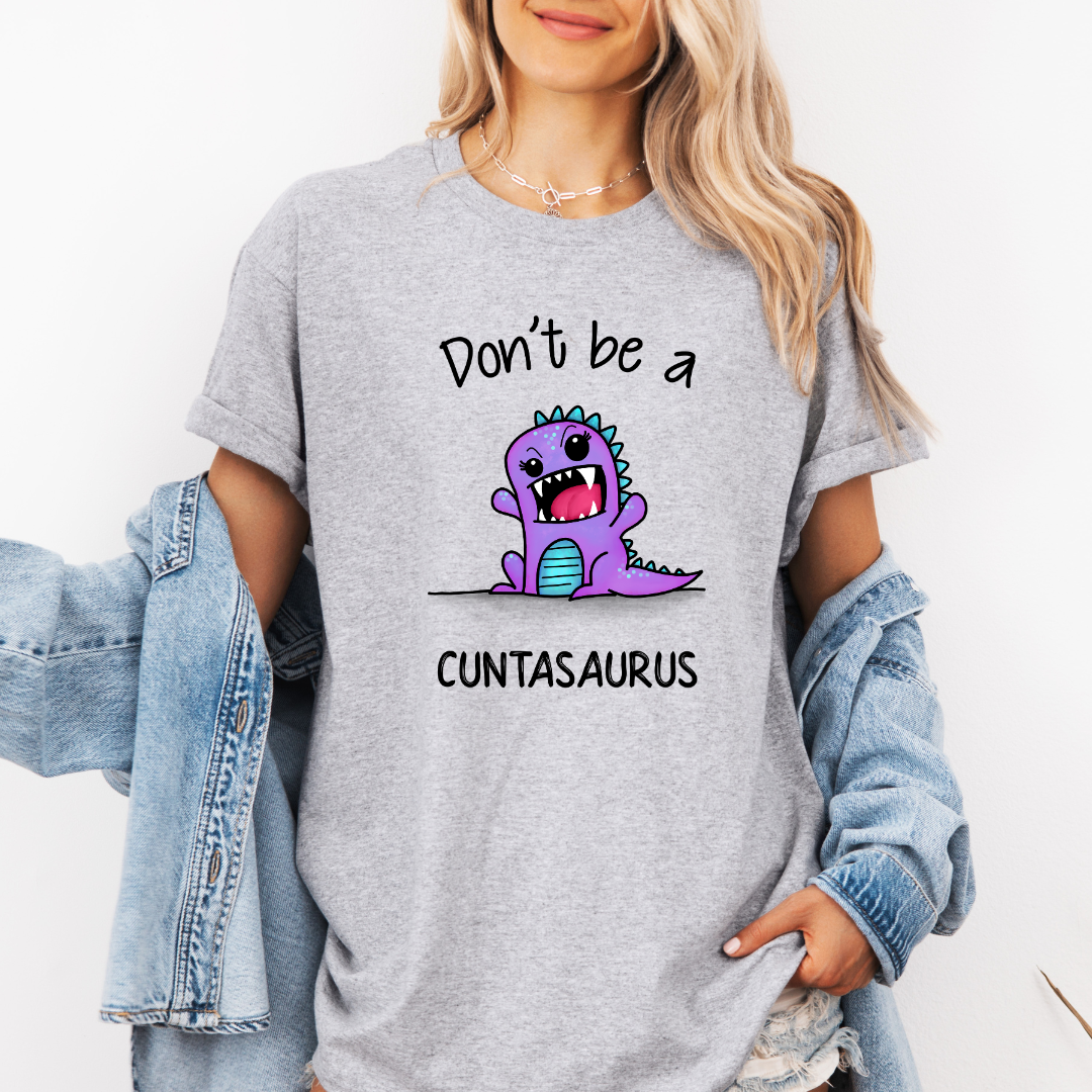 Female Model wearing a grey Don’t Be a Cuntasaurus Funny Dinosaur soft graphic t-shirt, showcasing its unique design and comfortable fit from Coffee and Moo.