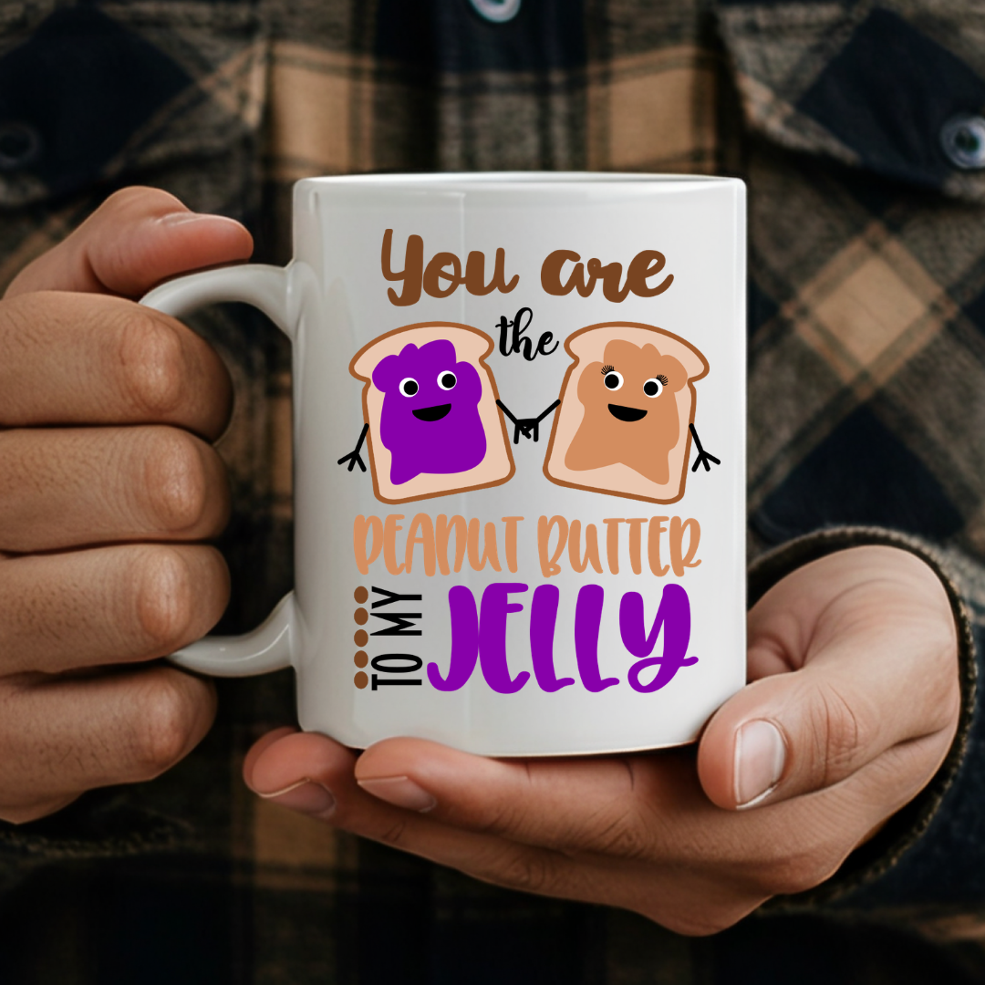 Male holding one 11oz mug from the Peanut Butter & Jelly humorous coffee mug set, showcasing the design, by Coffee and Moo.
