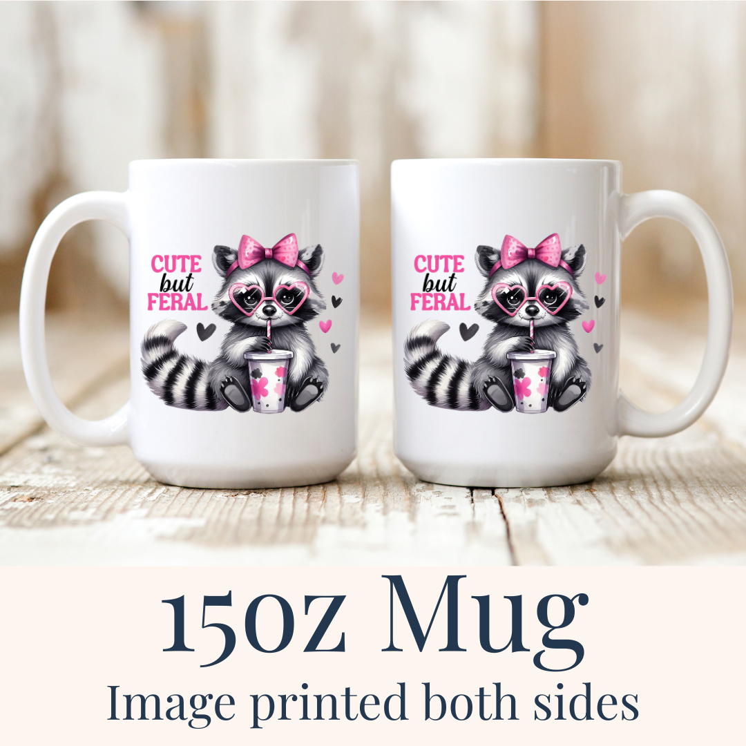 15oz Cute But Feral Raccoon ceramic mugs, with the "Cute but feral" design visible on both sides, from Coffee and Moo.
