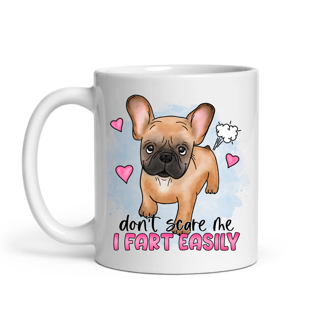 Don’t Scare Me I Fart Easily French Bulldog funny coffee mug showing the full "Don’t scare me I fart easily" design with a tan French Bulldog and hearts, from Coffee and Moo.