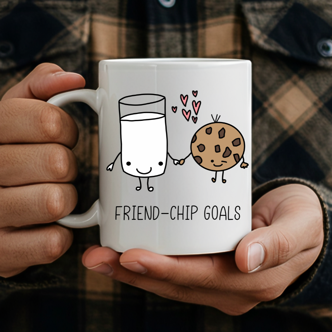 Adult holding Friend-chip Goals humorous coffee mug, showcasing the cute pun and comfortable grip, by Coffee and Moo.