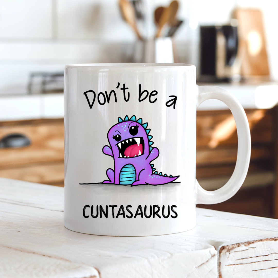 Cuntasaurus funny coffee mug on a country kitchen bench, adding humour to a rustic setting, by Coffee and Moo.