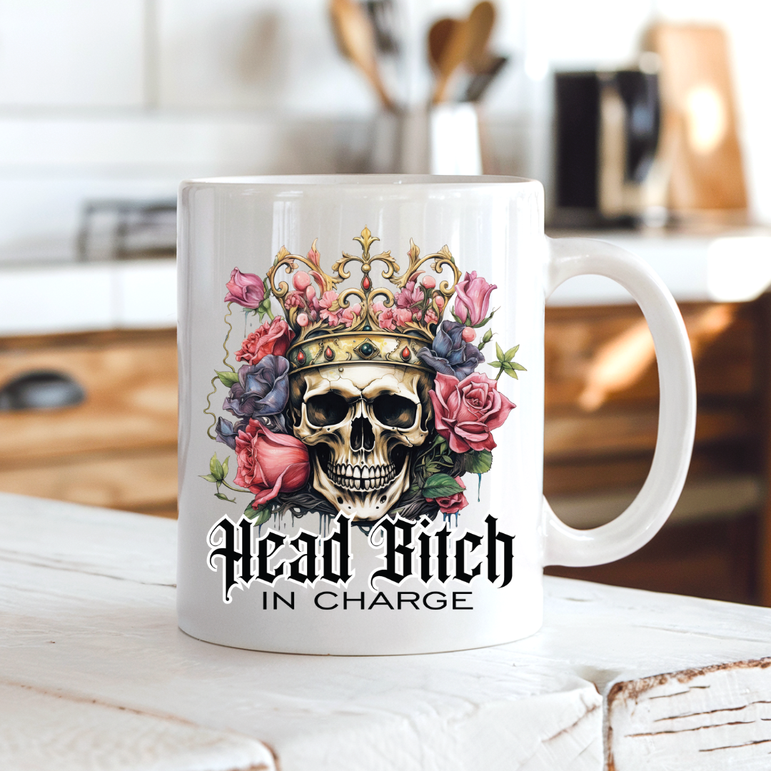 Head Bitch In Charge funny mug on a dark mahogany desk, the perfect accessory for a powerful home office, by Coffee and Moo.