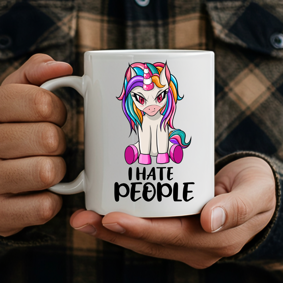 person holding I Hate People Unicorn humorous coffee mug, showcasing the design and comfortable grip, by Coffee and Moo.