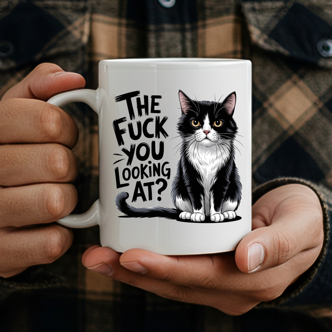 Male holding The Fuck You Looking At Cat humorous coffee mug, showcasing the design and comfortable grip, by Coffee and Moo.