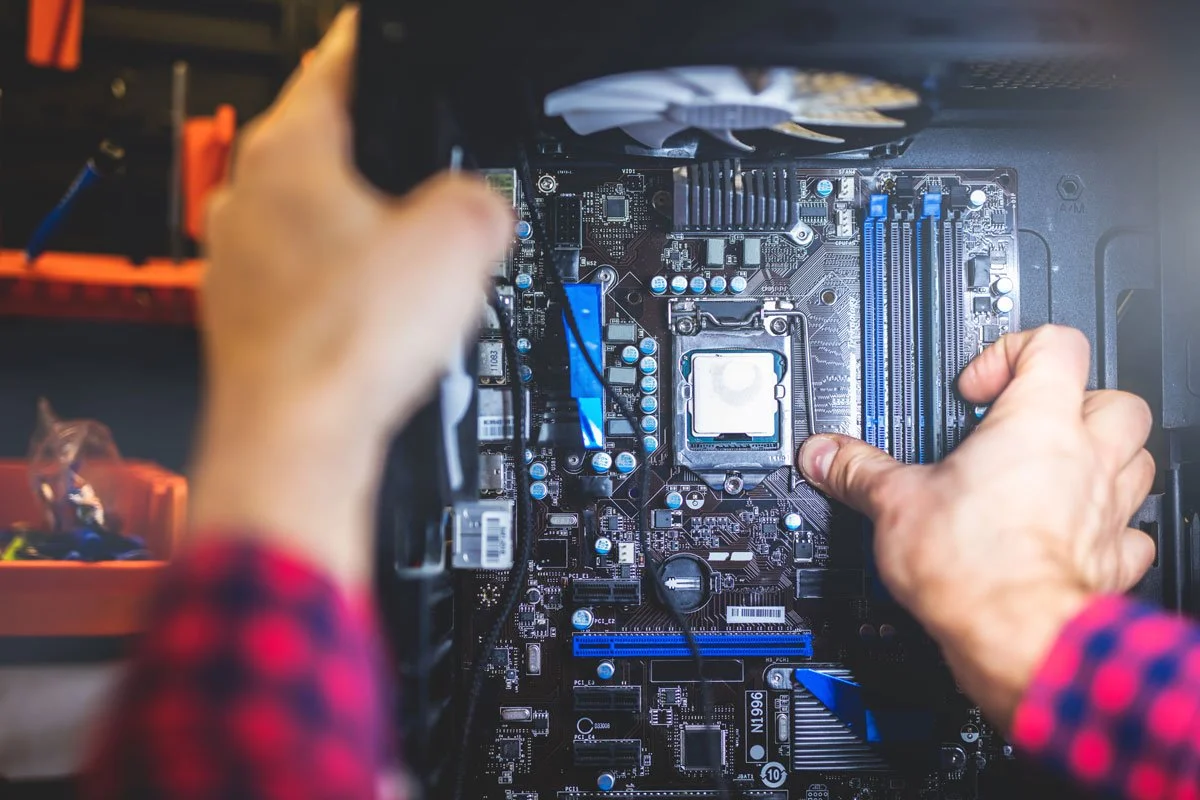 Person installing a CPU onto a computer motherboard.