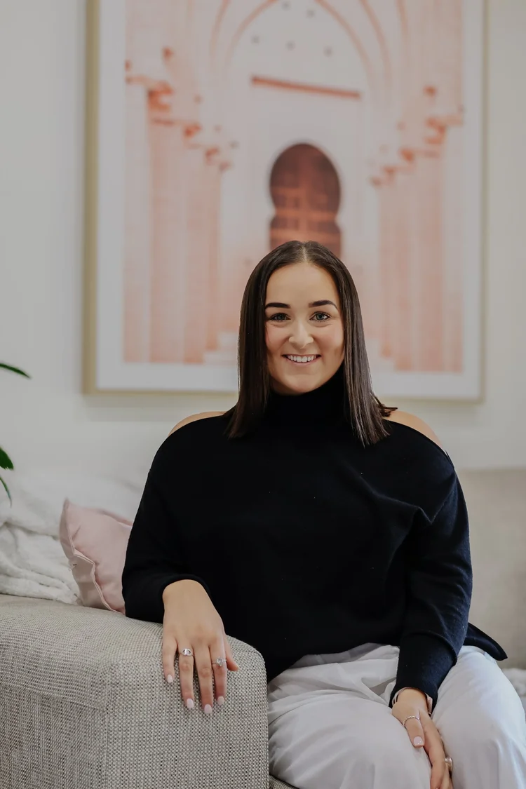 Maddi, founder of Maddi's House of Beauty, sitting in the salon