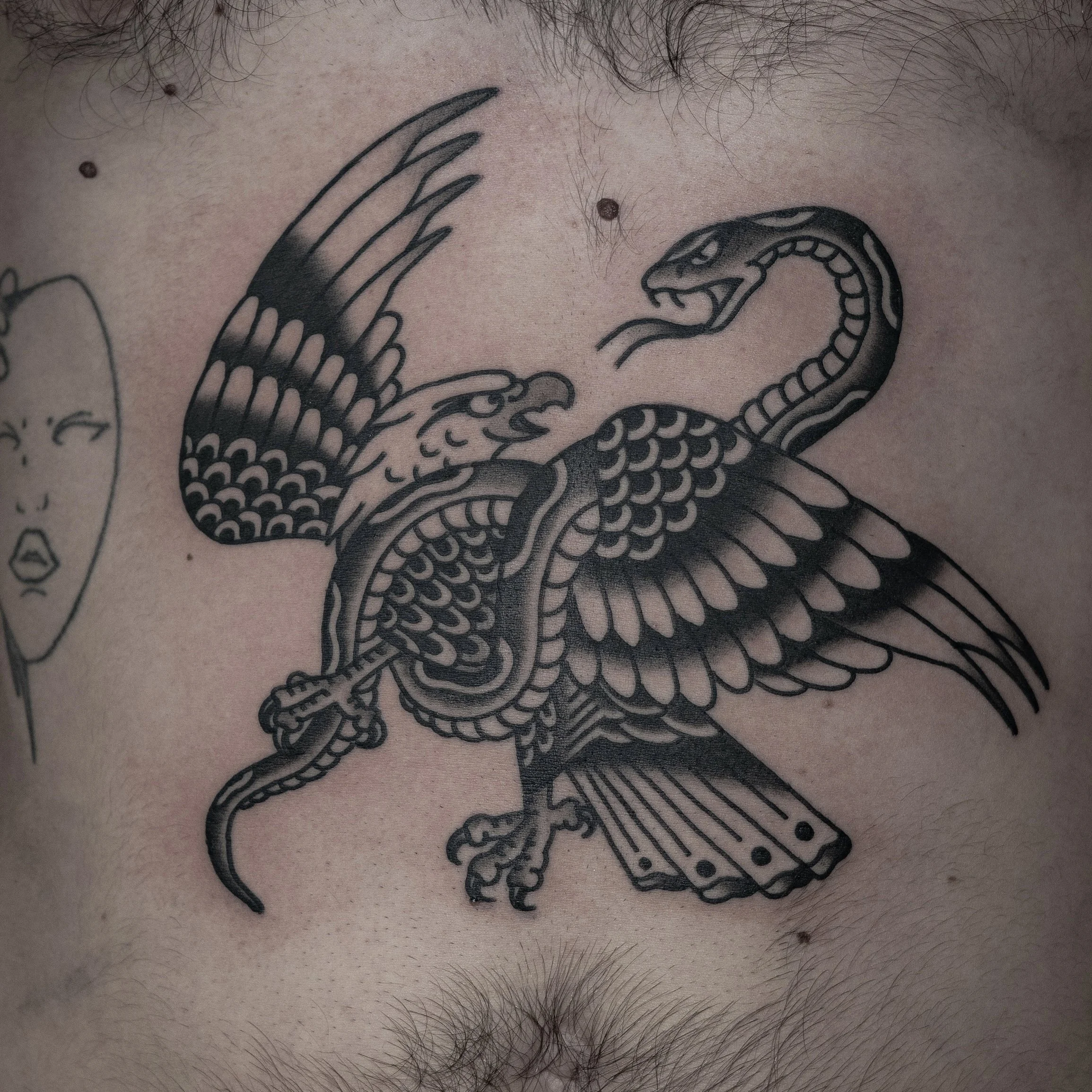 Tattoo of a snake and bird on a person's chest.