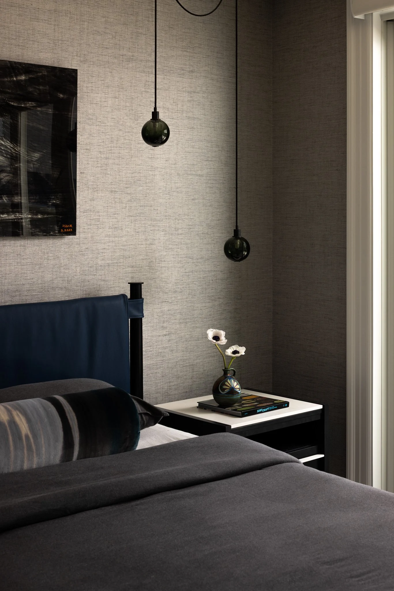 dark grey and navy bed with small dramatic globe lights