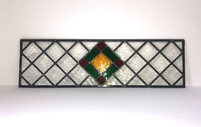 Decorative rectangular stained glass mirror with a central green diamond, red accents, and a gold circle, framed by a black grid pattern.
