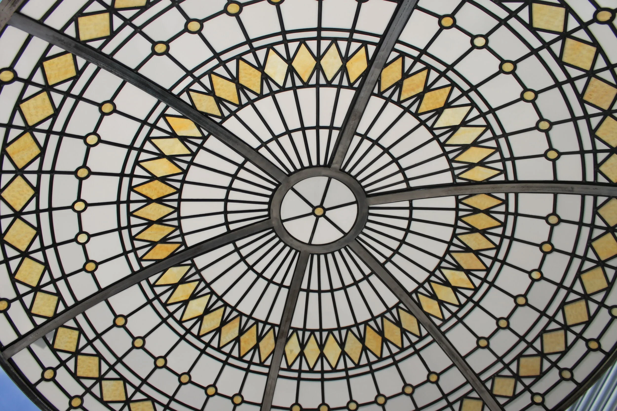 Stained glass dome ceiling with geometric patterns and yellow accents.