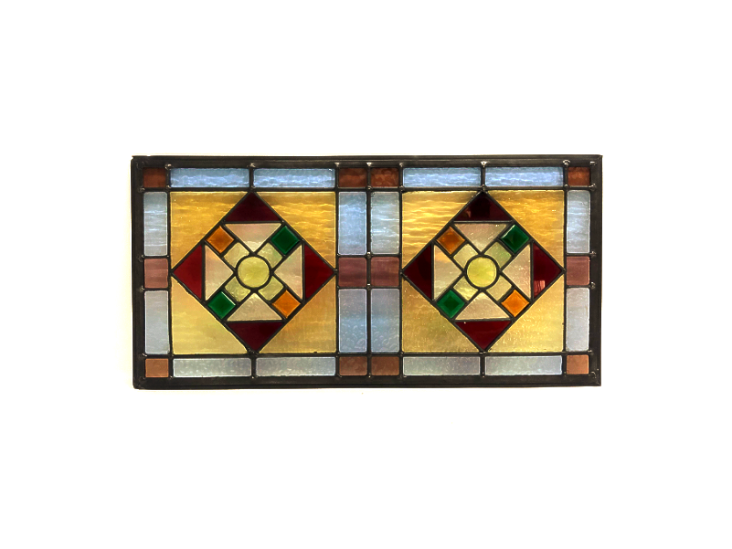 A decorative stained glass window with geometric patterns in red, yellow, green, blue, and brown colors